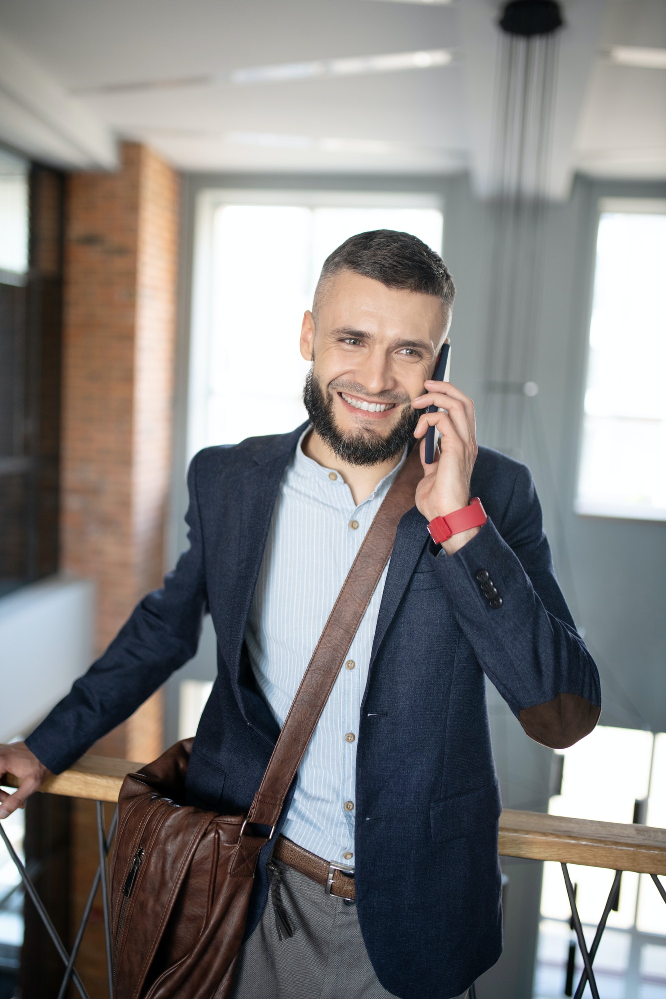 smiling-businessman-speaking-with-colleague-by-the-phone.jpg