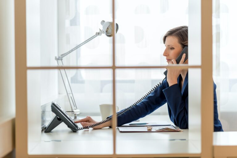 Young businesswoman or secretary dialing a phone number