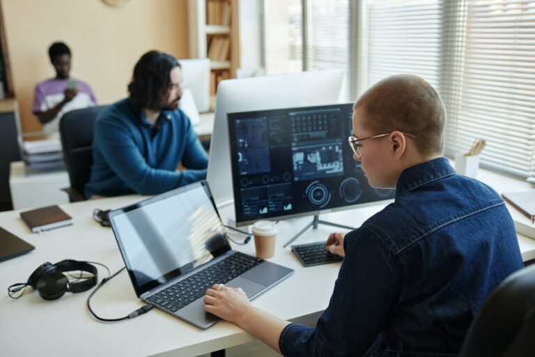 Young female cyber security manager using laptop while working with data