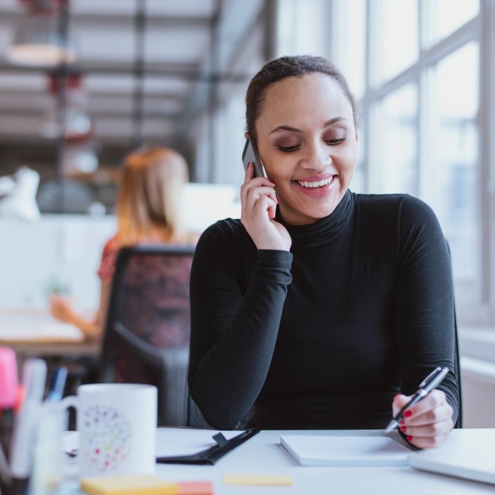 woman-answering-a-phone-call-while-at-work.jpg